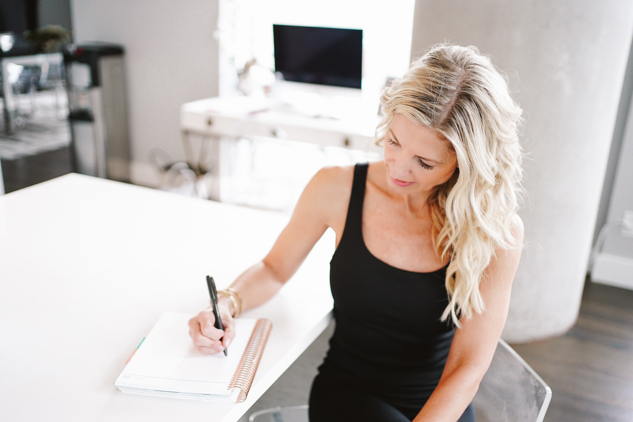 girl in workout clothes writing in erin condren journal, goal setting 2021